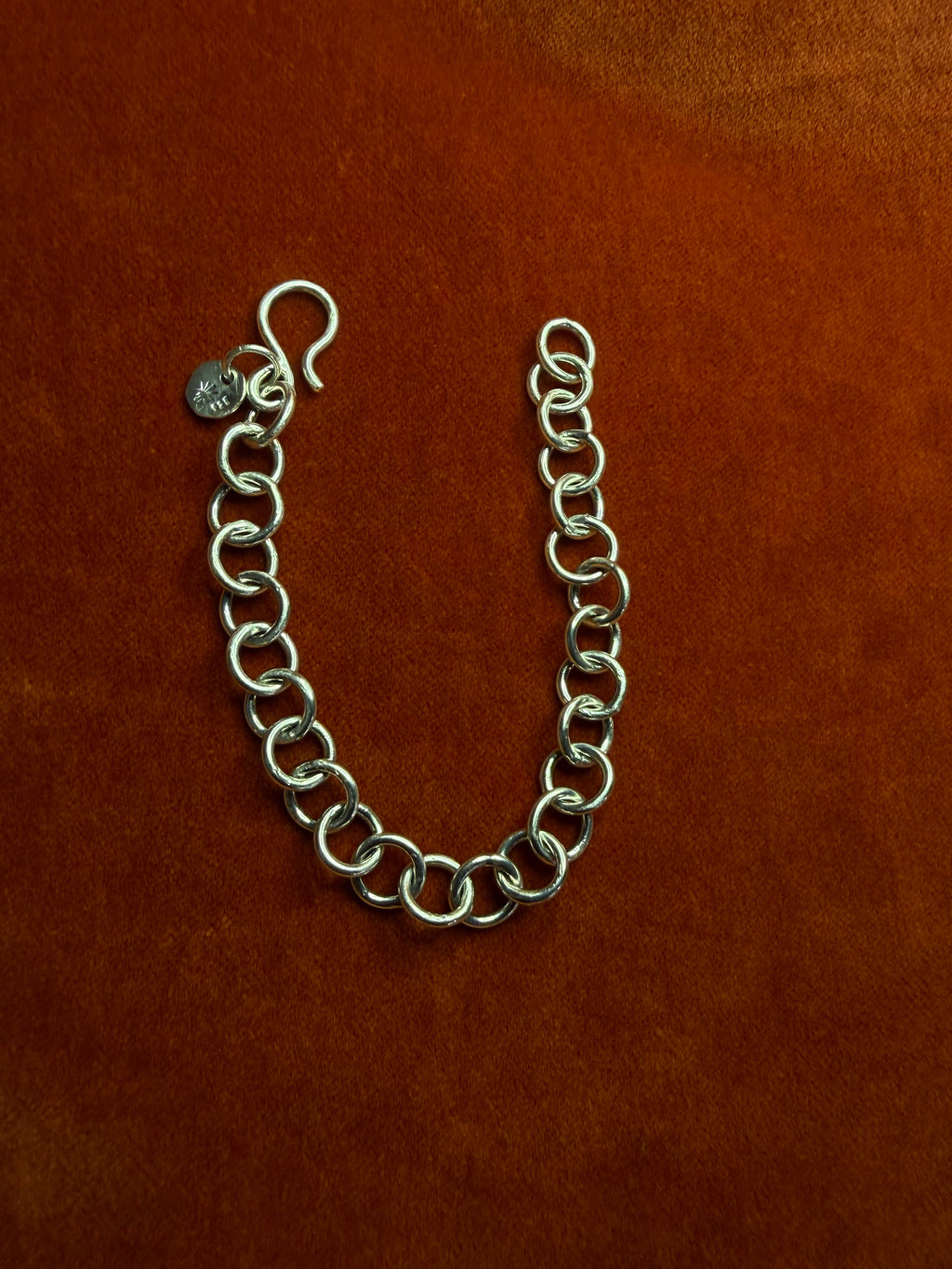 Sterling silver chunky chain displayed on an orange velvet backdrop.