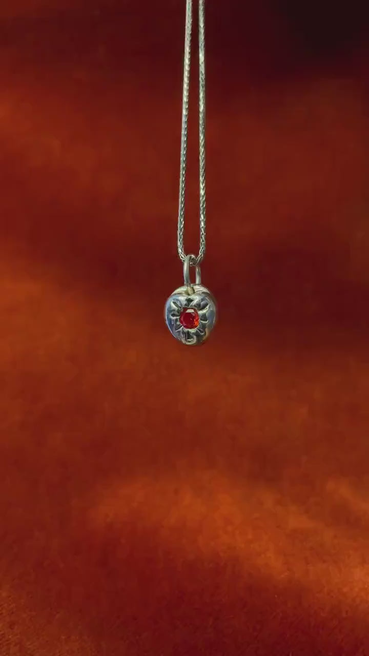 Silver Chunky Heart Charm with red gemstone dangling on a silver necklace rotating.