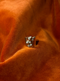 Close up image of a silver ring with a chunky hammered texture band. Seven varying sizes of orbs sit asymmetrically on top of the band.
