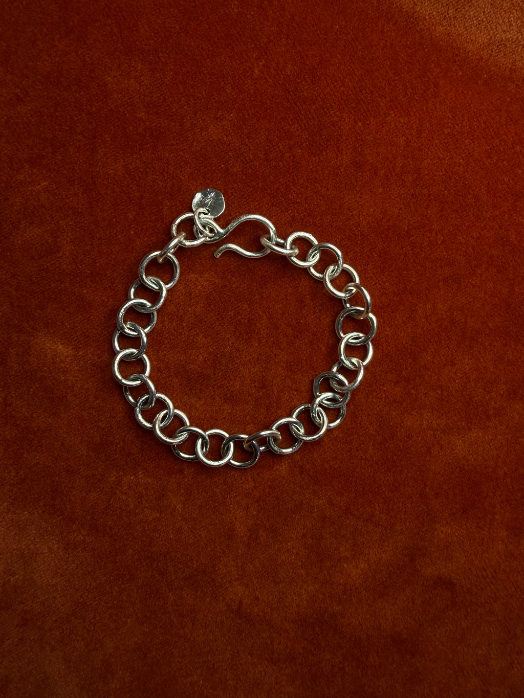 Sterling silver chunky chain displayed on an orange velvet backdrop. Featuring a hook clasp.