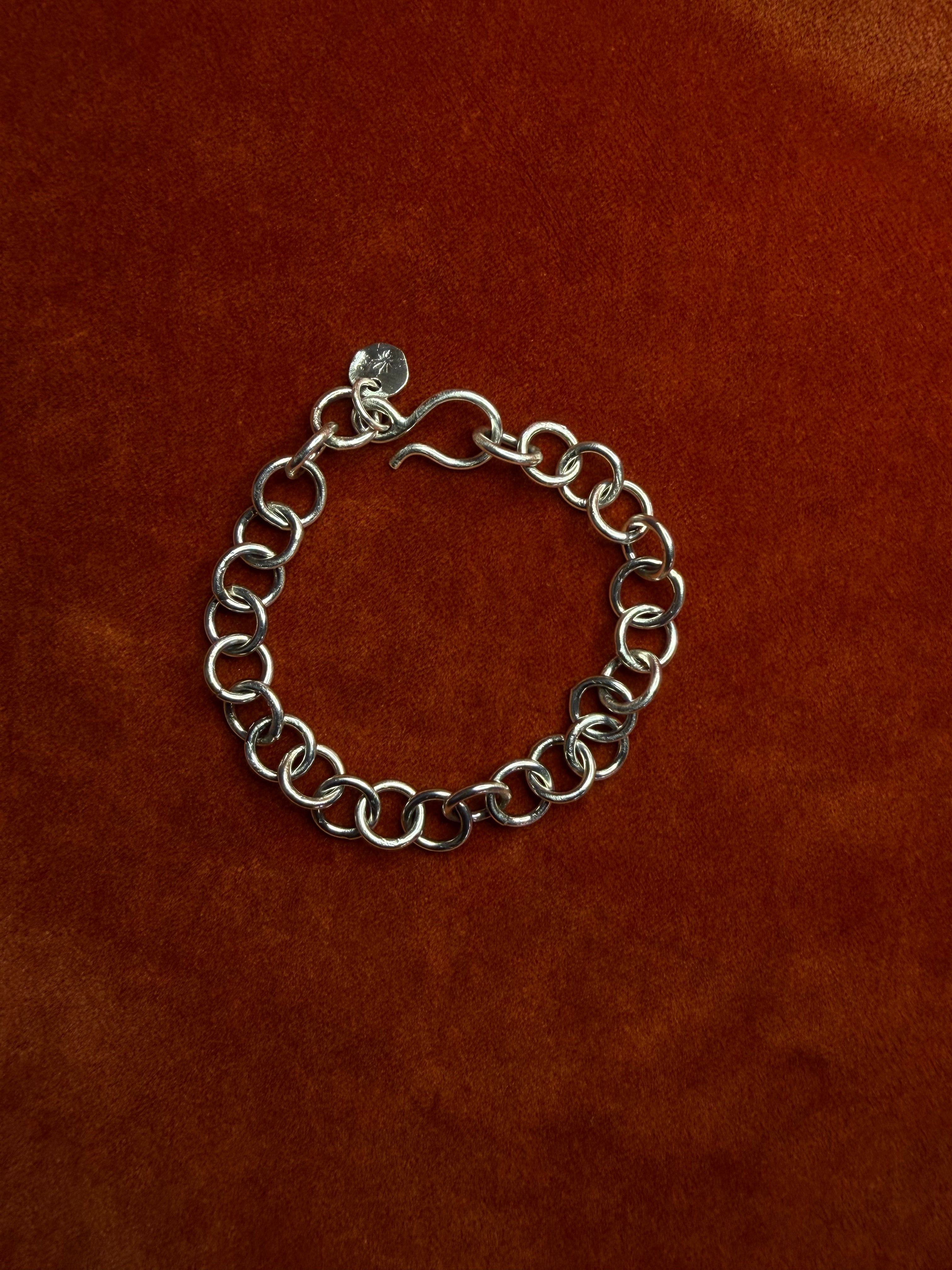Sterling silver chunky chain displayed on an orange velvet backdrop. Featuring a hook clasp.